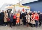 Gruppenfoto mit Innenminister Herrmann und Einsatzkräften des BRK vor Rettungswagen