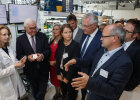 Gruppe von Menschen bei Führung durch das Institut, darunter Bundespräsident Frank-Walter Steinmeier und Innenminister Joachim Herrmann, Frau in weißem Laborkittel erklärt etwas