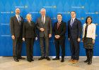 Gruppenfoto von Herrmann und der US-Delegation vor der Pressewand des StMI