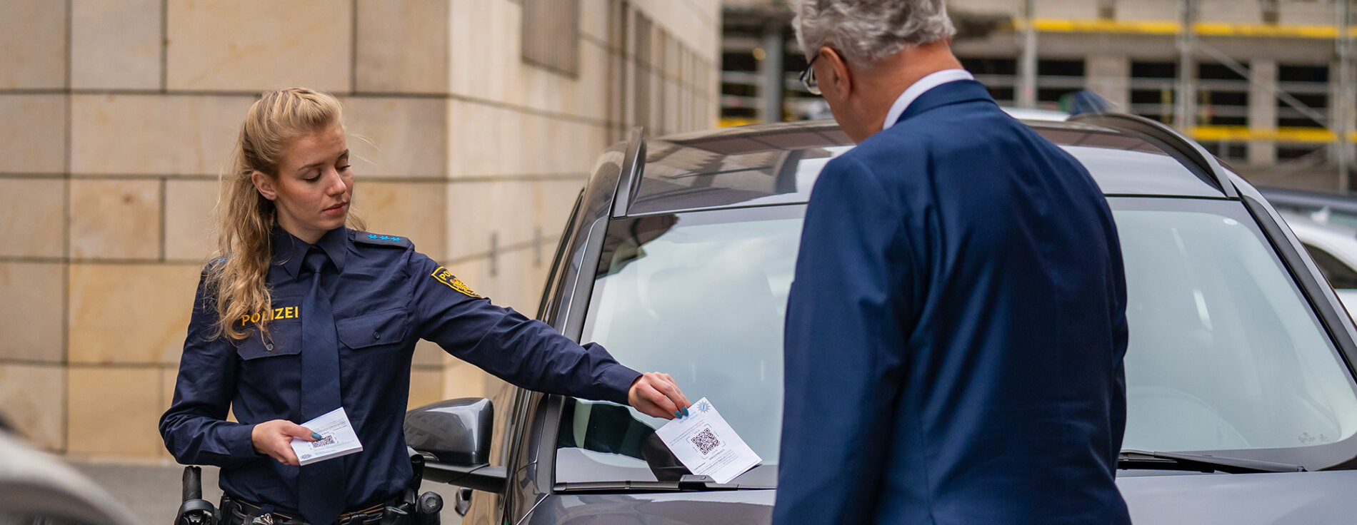 Polizistin steckt Strafzettel an Auto, Innenminister Joachim Herrmann von hinten