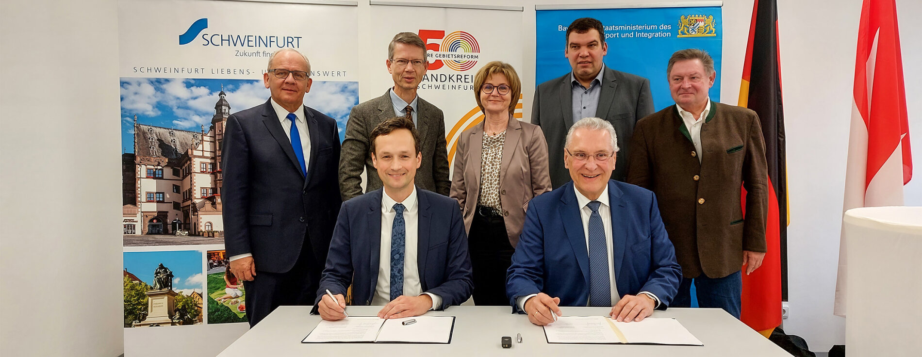 Herrmann und Vertreter des Zweckverbands bei Unterschrift, im Hintergrund Gerhard Eck und weitere Personen