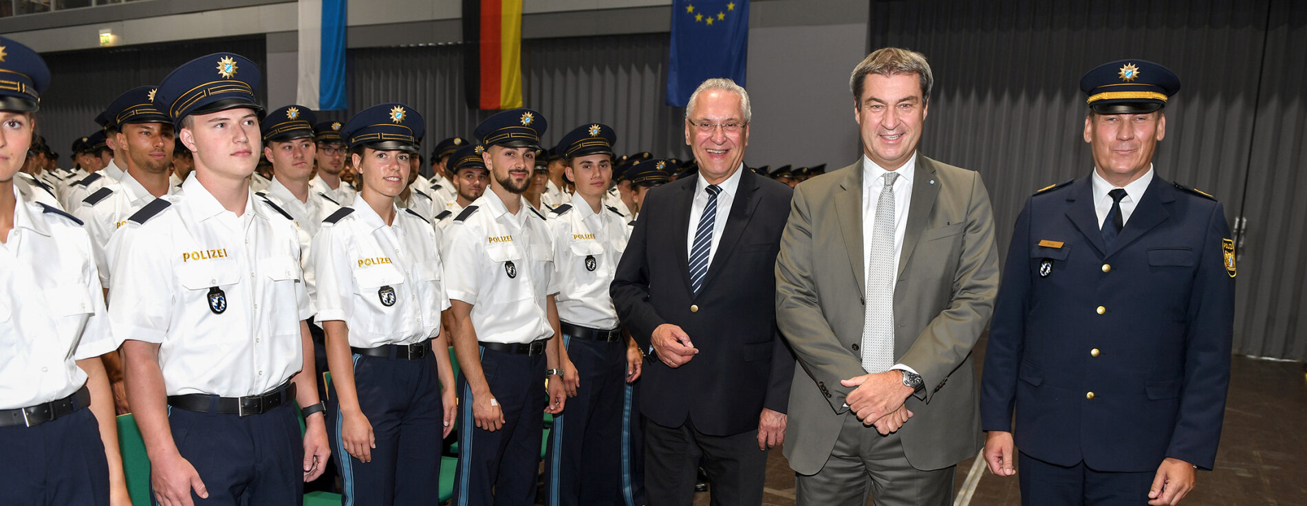 Innenminister Joachim Herrmann neben Ministerpräsident Dr. Markus Söder und Polizeibeamter neben vereidigten Polizistinnen und Polizisten