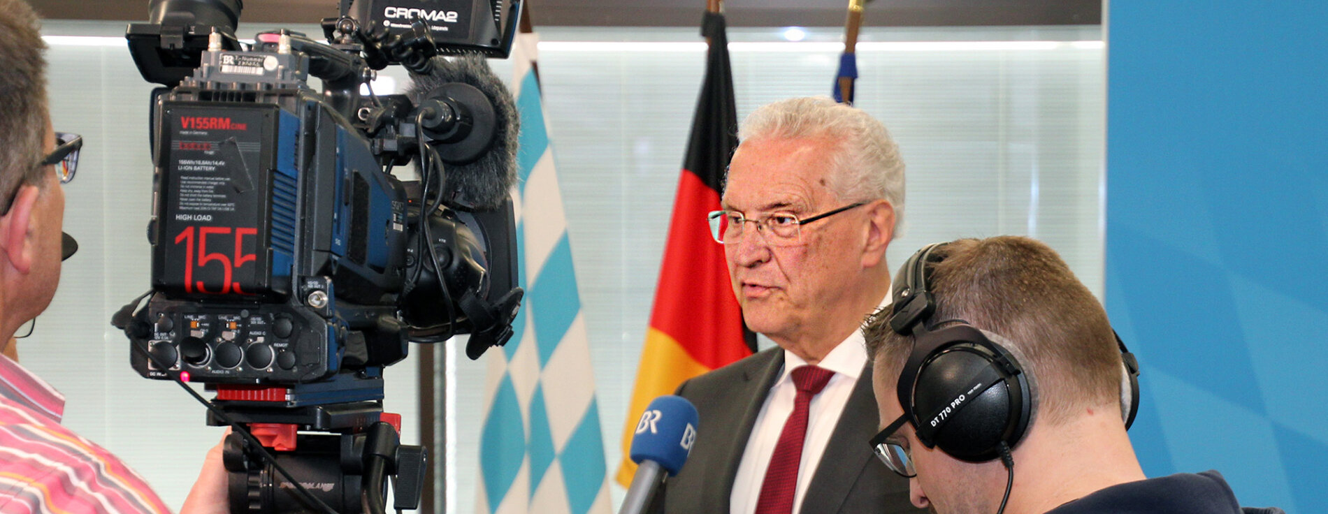 16. Mai 2025: Bei der Vorstellung der neuen Bevölkerungsvorausberechnung bis 2043 hebt Innenminister Joachim Herrmann hervor: Bayern wächst moderat und wird spürbar älter – besonders im ländlichen Raum. Die Prognose liefert wichtige Impulse für eine vorausschauende Zukunftsplanung. Innenminister Joachim Herrmann vor einer Kamera des Bayerischen Rundfunks