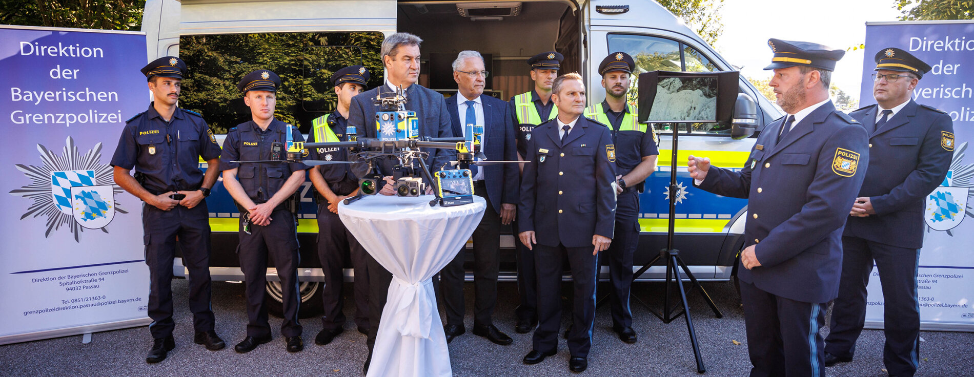 Söder und Herrmann bei Pressekonferenz vor Polizeiauto mit Grenzpolizisten in Uniform. Im Vordergrund Polizeidrohne