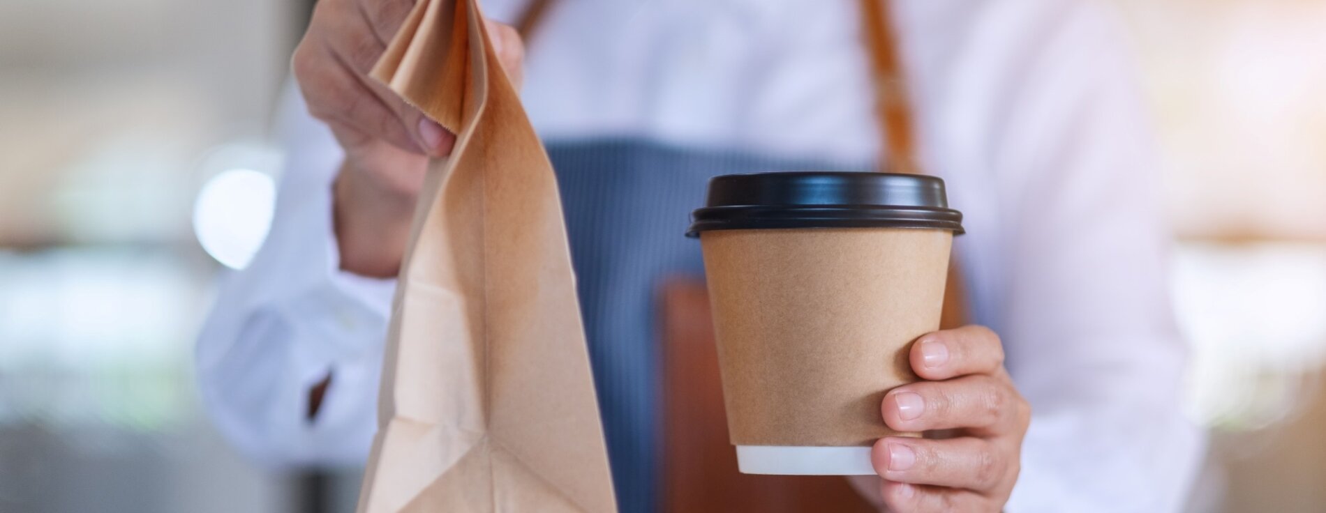 Der Ministerrat lehnt auf Vorschlag von Innen- und Kommunalminister Joachim Herrmann kommunale Verpackungssteuer im Freistaat ab. Frau hält einen Coffee-to-go-Becher und eine Papiertüte in der Hand