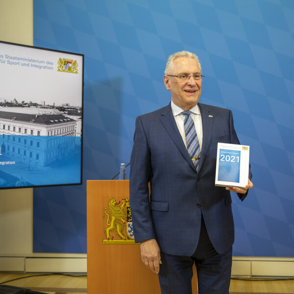 Innenminister Joachim Herrmann mit Verfassungsschutzbericht in der Hand
