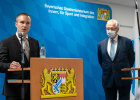 Der neue Präsident Axel Ströhlein hinter dem Rednerpult bei seiner Ansprache. Etwas nach hinten versetzt steht Innenminister Joachim Herrmann mit Mund-Nasen-Bedeckung.