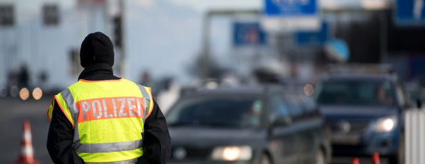 Ein Polizist beobachtet den Grenzverkehr an einer Autobahn