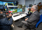 Innenminister Joachim Herrmann vor Monitore mit Fahrsimulation, im Hintergrund Polizeisimulator