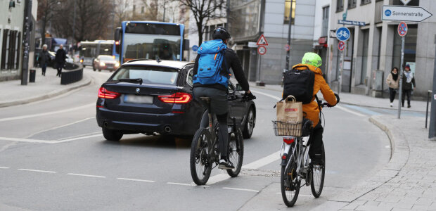 Radfahrer im Straßenverkehr - © Sammy Minkoff Auf dem Bild sind zwei Radfahrer von hinten zu sehen, die im Straßenverkehr in München unterwegs sind