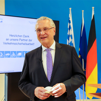 Innenminister Joachim Herrmann neben Präsentationsbildschirm
