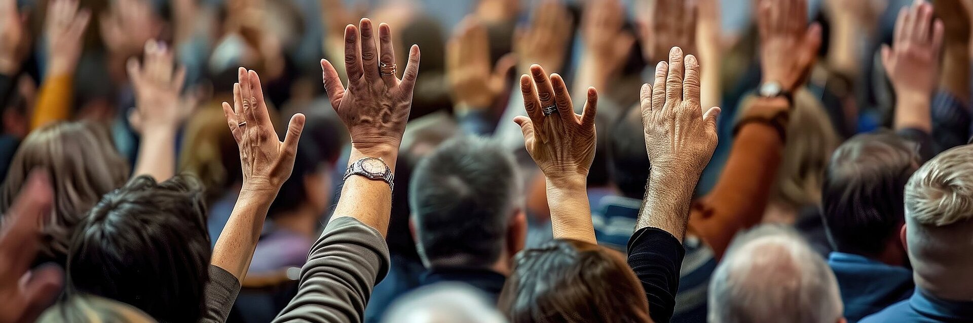 Menschenmenge von hinten mit erhobenen Händen
