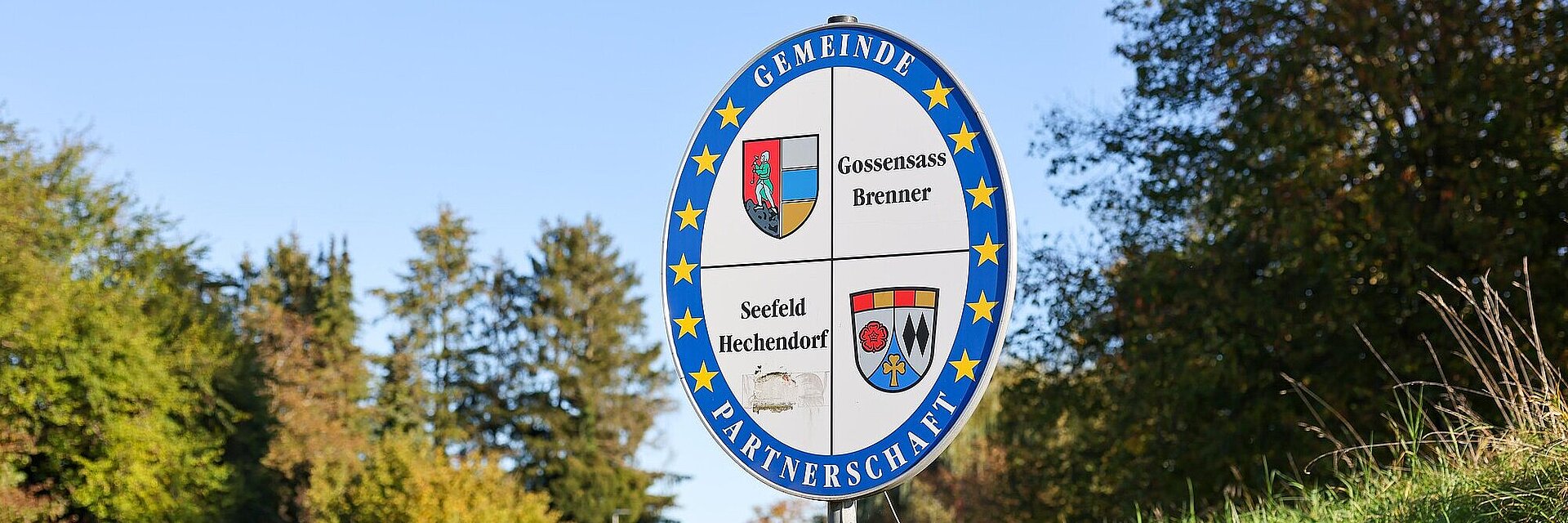 Schild am Straßenrand mit Städtepartnerschaft Seefeld Hechendorf und Gossensass Brenner